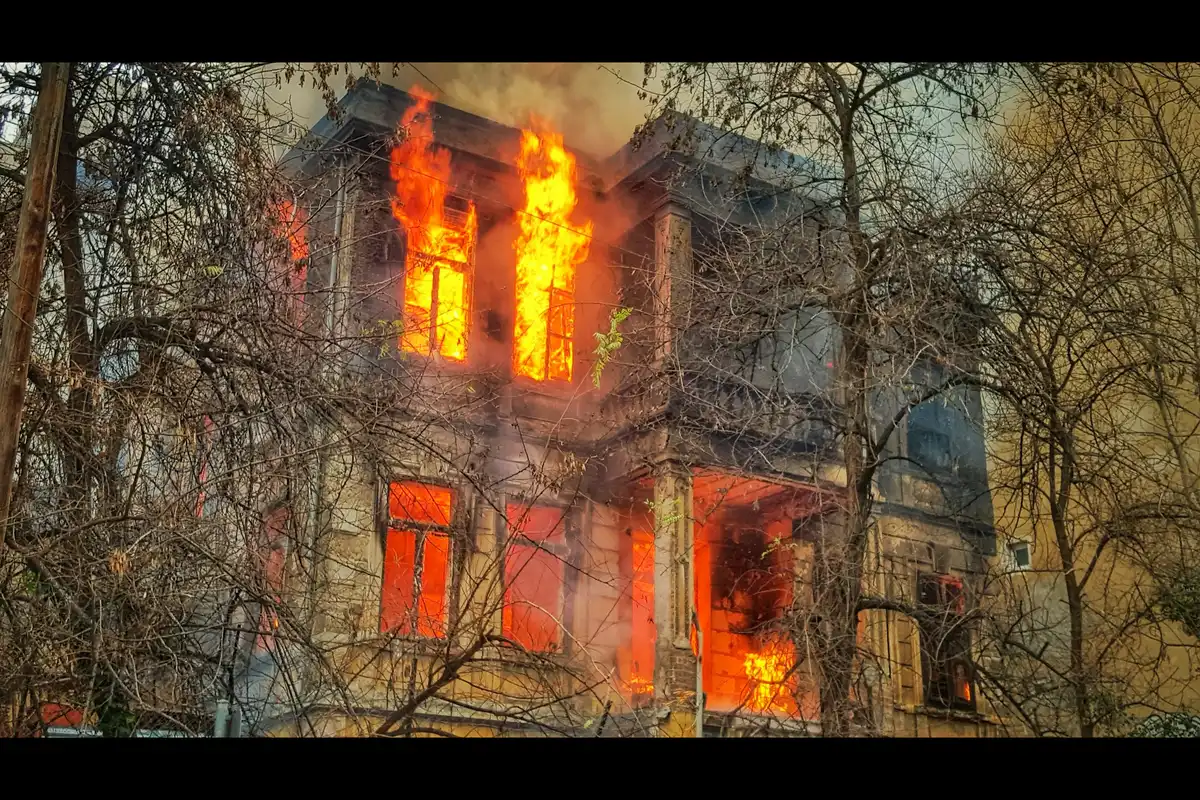 Flames coming out of the windows of a two-story house